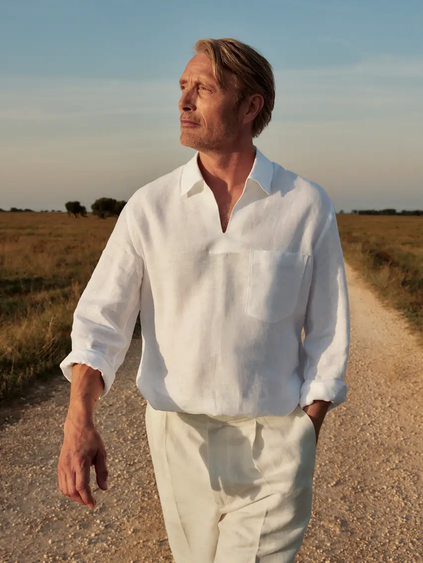 Mads Mikkelsen wearing a refined linen outfit paired with suede loafers from the ZEGNA SS25 collection.