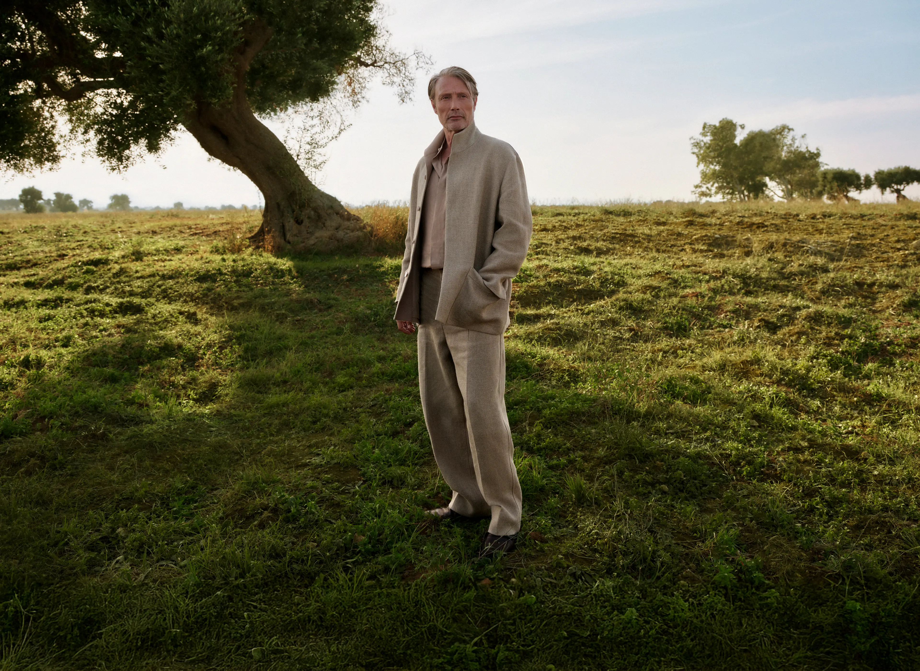 Mads Mikkelsen wearing a refined linen outfit paired with leather loafers from the ZEGNA SS25 collection.
