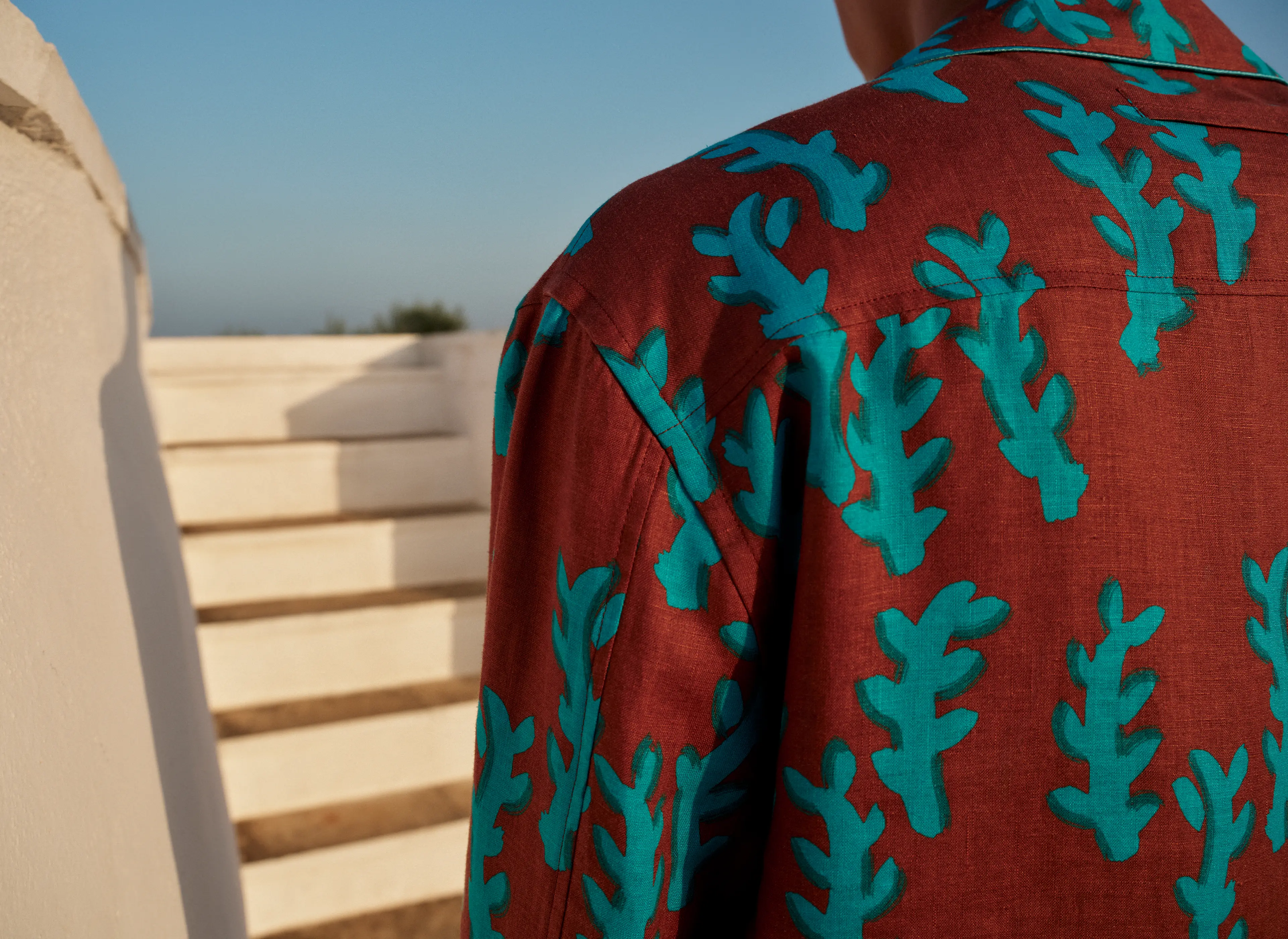 Man wearing a bold printed summer set featuring a relaxed-fit buttoned shirt and matching shorts by ZEGNA.