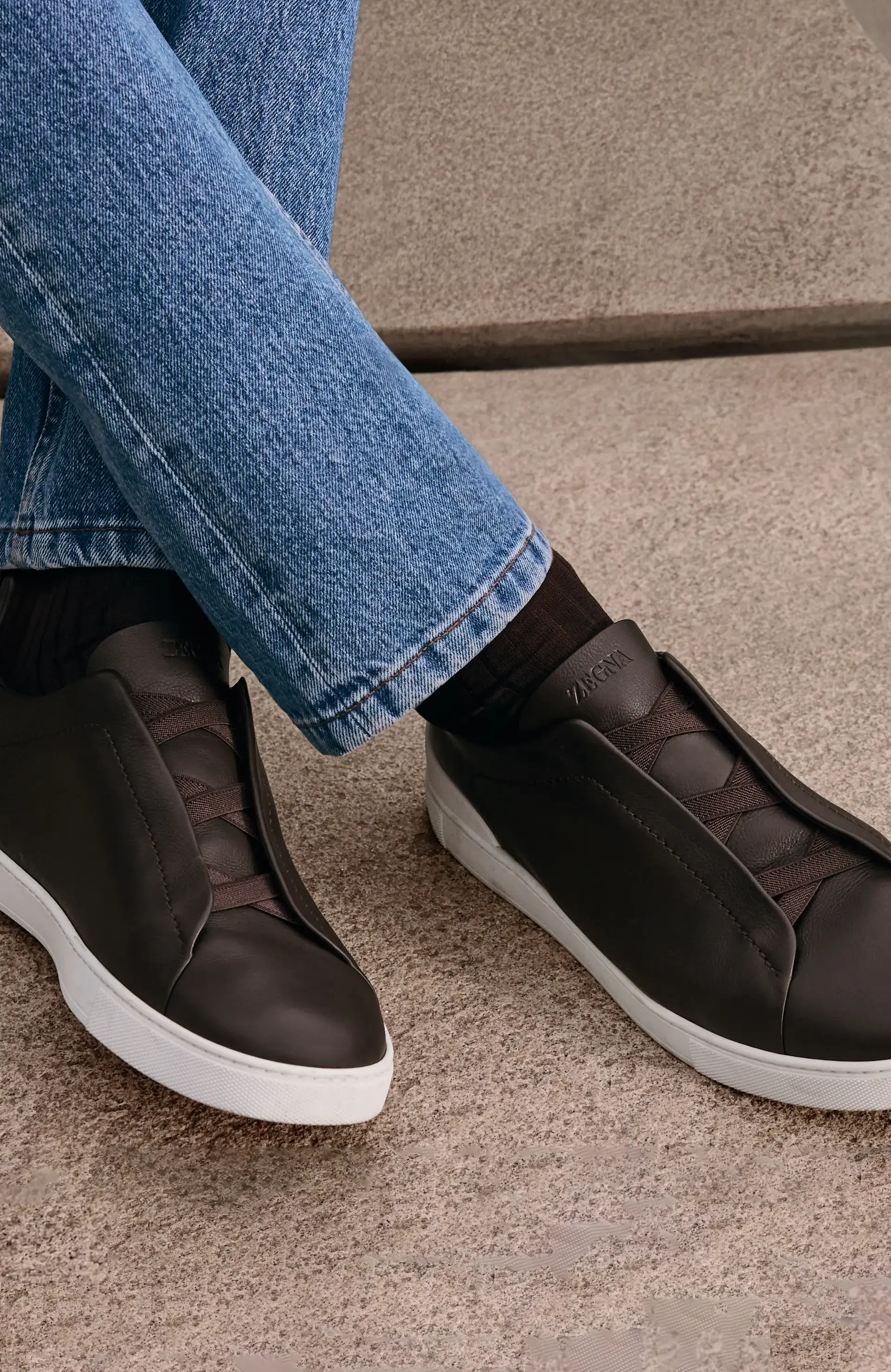 Man wearing luxury Triple Stitch™ sneakers with denim, from the ZEGNA Fall/Winter 2025 collection.